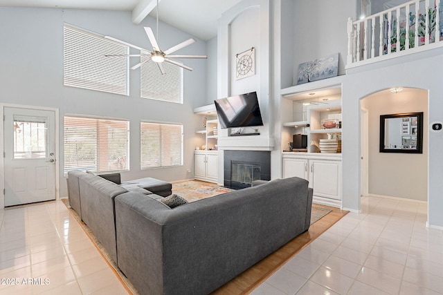 901 W Beck Ln, Phoenix, AZ 85023 - living room featuring a ceiling fan, a glass covered fireplace, built in features, light tile patterned floors, and baseboards
