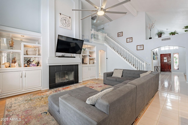 901 W Beck Ln, Phoenix, AZ 85023 - living area featuring light tile patterned flooring, visible vents, built in shelves, stairway, and arched walkways