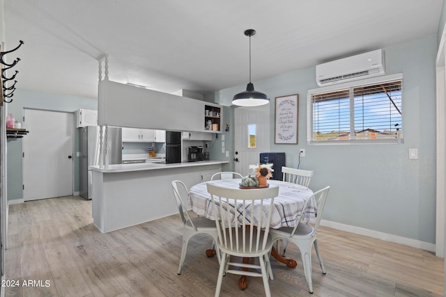 dining area with an AC wall unit and light wood-type flooring