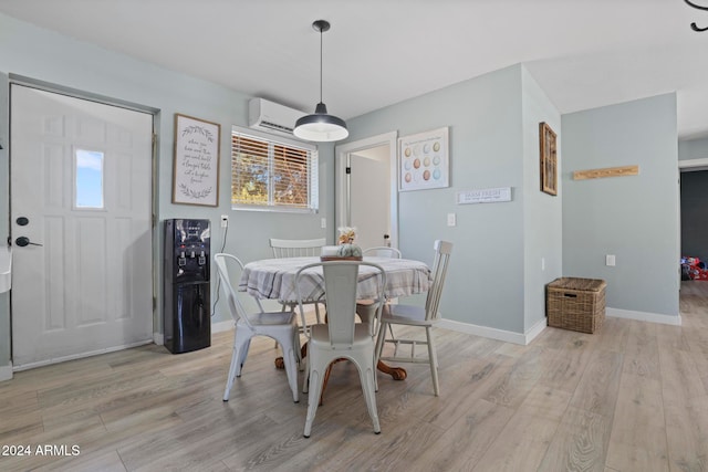 dining room featuring light wood-type flooring and a wall unit AC