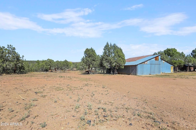 view of yard featuring an outdoor structure and a rural view