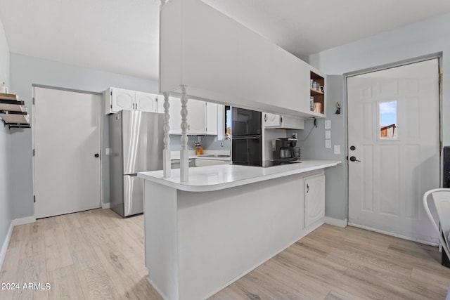 kitchen with stainless steel refrigerator, light hardwood / wood-style flooring, sink, kitchen peninsula, and white cabinetry