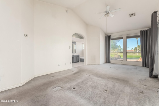 spare room featuring high vaulted ceiling, light carpet, and ceiling fan