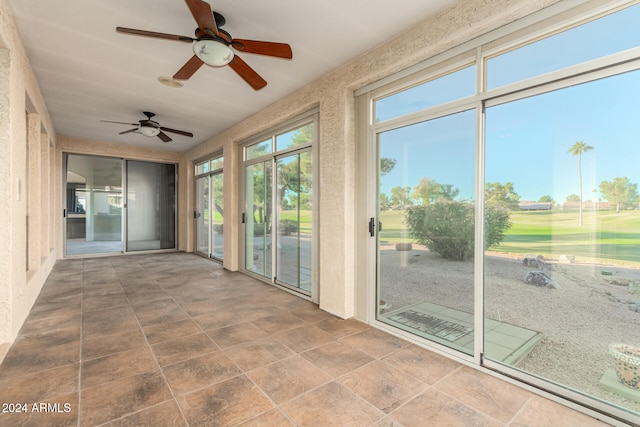 unfurnished sunroom featuring ceiling fan