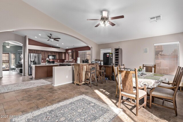 bar with lofted ceiling, ceiling fan, and appliances with stainless steel finishes