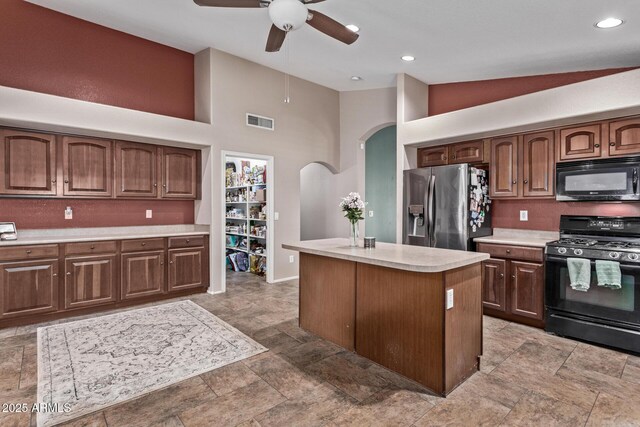 carpeted bedroom with vaulted ceiling and stainless steel fridge