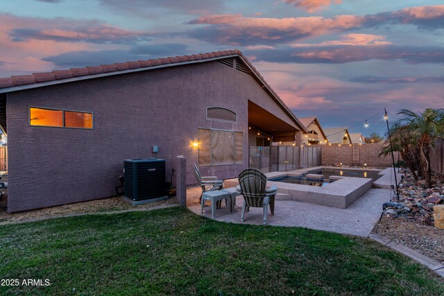 back of house with a garage, covered porch, and a lawn