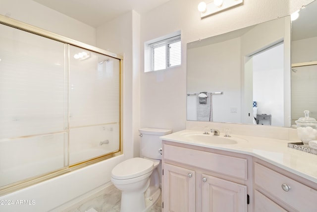 full bathroom featuring toilet, combined bath / shower with glass door, and vanity