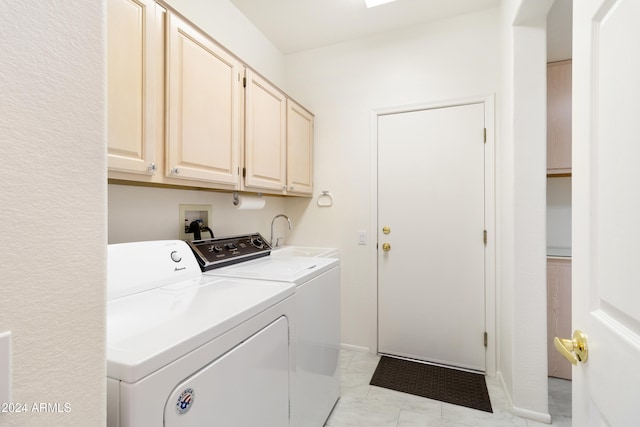 clothes washing area with sink, cabinets, and washing machine and clothes dryer