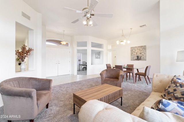 living room with ceiling fan with notable chandelier