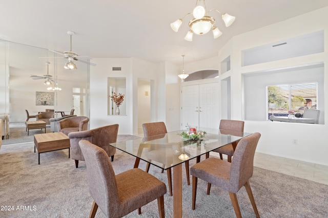 dining area with light tile patterned floors and ceiling fan with notable chandelier