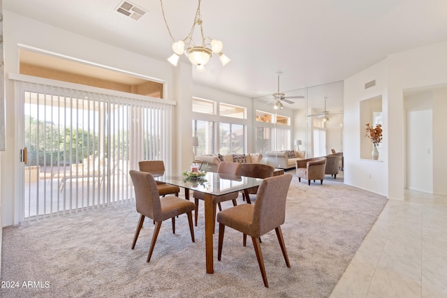 carpeted dining room featuring ceiling fan with notable chandelier