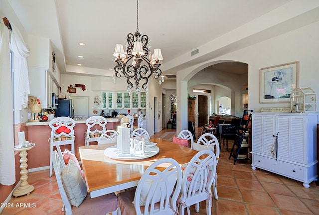 tiled dining room with an inviting chandelier