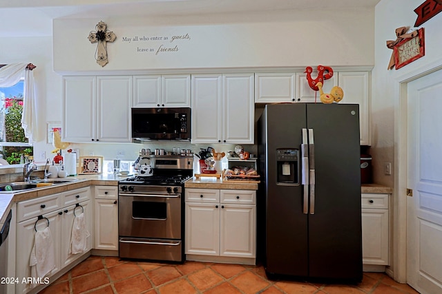 kitchen featuring light tile patterned flooring, stainless steel appliances, white cabinetry, and sink