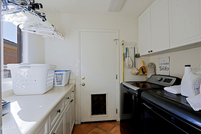 laundry room with cabinets, washer and dryer, and dark tile patterned floors