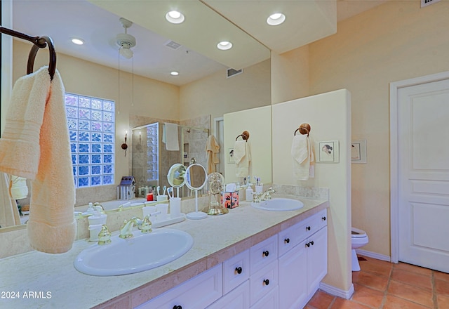 bathroom with toilet, vanity, a shower with door, and tile patterned floors