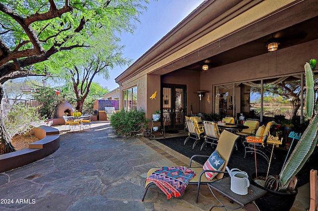 view of patio / terrace featuring french doors and a fireplace