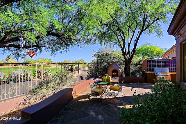 view of patio featuring grilling area, an outdoor fireplace, and exterior kitchen