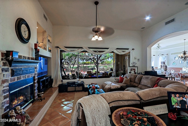 tiled living room featuring a tiled fireplace and a notable chandelier