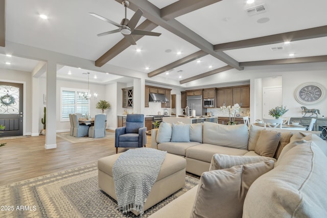 living room featuring vaulted ceiling with beams, light wood-type flooring, visible vents, and baseboards