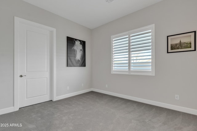 unfurnished room featuring carpet, visible vents, and baseboards