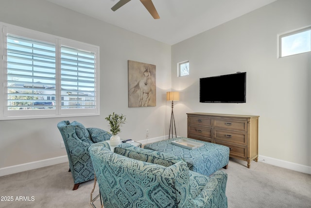 living area featuring light carpet, a healthy amount of sunlight, and baseboards