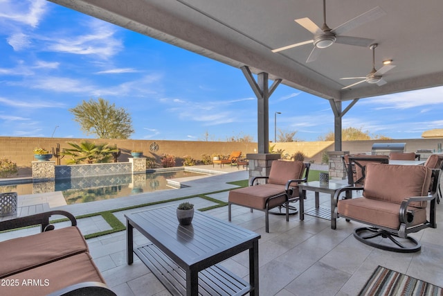 view of patio / terrace with exterior kitchen, a ceiling fan, a fenced backyard, and an outdoor hangout area