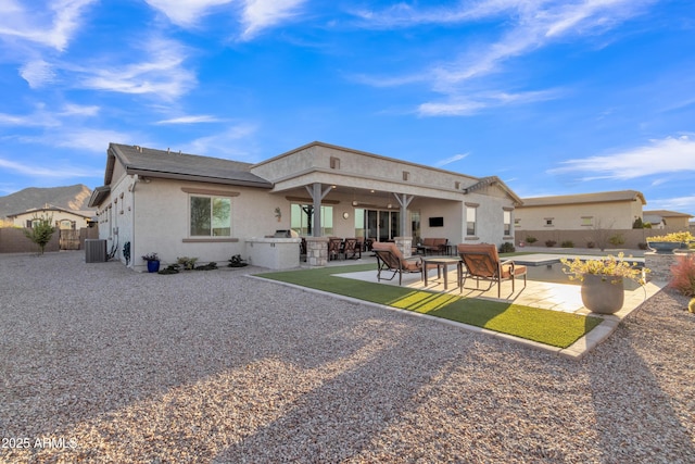 rear view of property featuring stucco siding, a patio area, central AC, a fenced backyard, and an outdoor living space