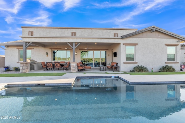 back of house with a patio, exterior kitchen, a ceiling fan, and stucco siding