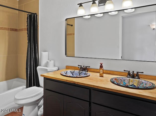 full bathroom featuring shower / tub combo with curtain, vanity, and toilet