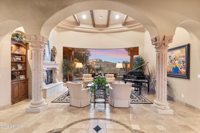 15956 E Tombstone Trl, Fountain Hills, AZ 85268 - sitting room with baseboards, ornate columns, beam ceiling, arched walkways, and stone tile flooring