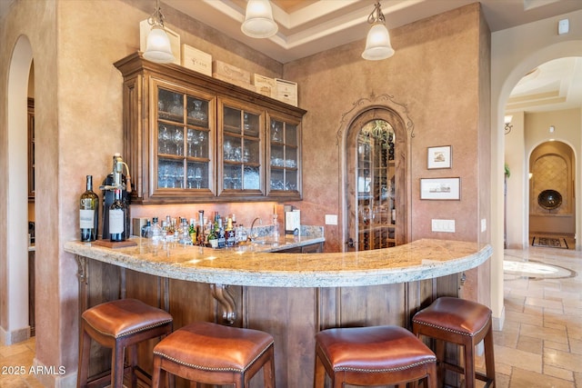 15956 E Tombstone Trl, Fountain Hills, AZ 85268 - bar featuring wet bar, a sink, arched walkways, and stone tile flooring