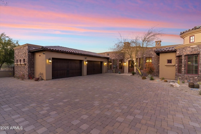 15956 E Tombstone Trl, Fountain Hills, AZ 85268 - mediterranean / spanish-style home with stone siding, stucco siding, a tiled roof, and a garage