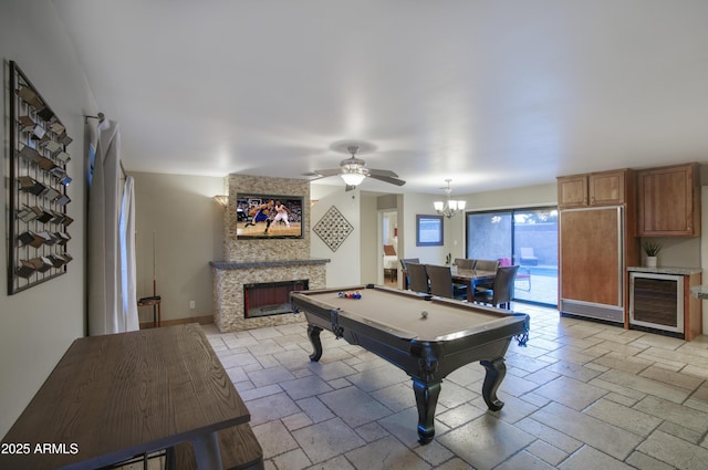 4008 N 85th St, Scottsdale, AZ 85251 - playroom with wine cooler, a fireplace, pool table, stone tile floors, and a ceiling fan