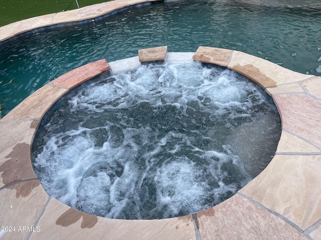 view of swimming pool featuring an in ground hot tub