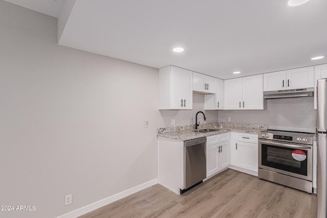 kitchen featuring light stone counters, sink, white cabinetry, and stainless steel appliances