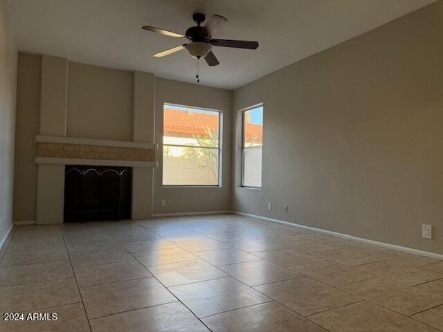 unfurnished living room featuring light tile patterned floors, a fireplace, and ceiling fan