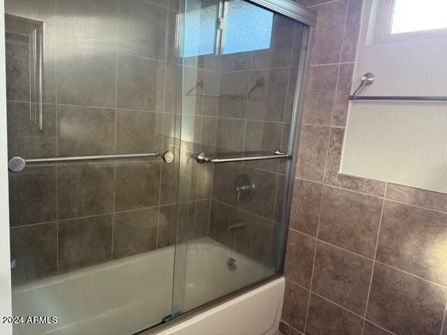 bathroom featuring bath / shower combo with glass door