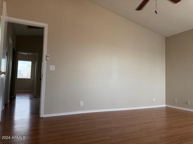 unfurnished room with vaulted ceiling, ceiling fan, and dark hardwood / wood-style floors