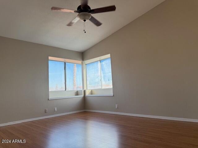 empty room with vaulted ceiling, hardwood / wood-style floors, and ceiling fan