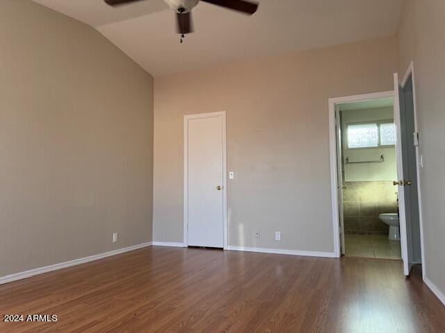 unfurnished bedroom featuring vaulted ceiling, dark hardwood / wood-style floors, ceiling fan, and ensuite bathroom