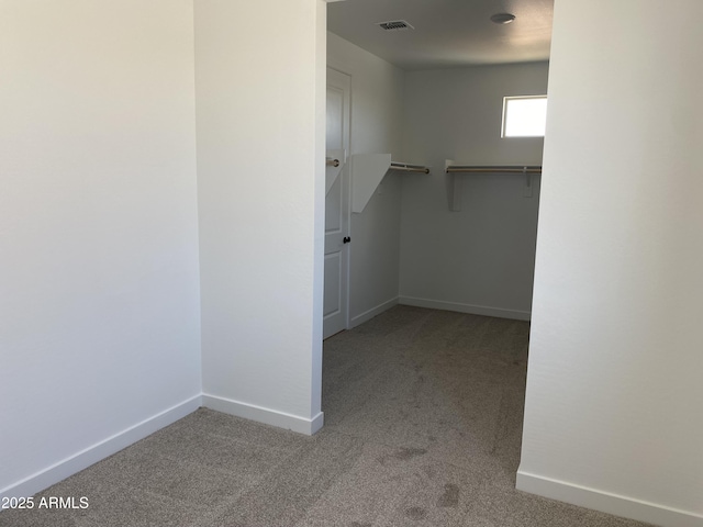 walk in closet featuring visible vents and carpet