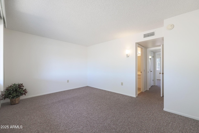 spare room with carpet flooring and a textured ceiling