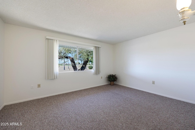 carpeted empty room featuring a textured ceiling