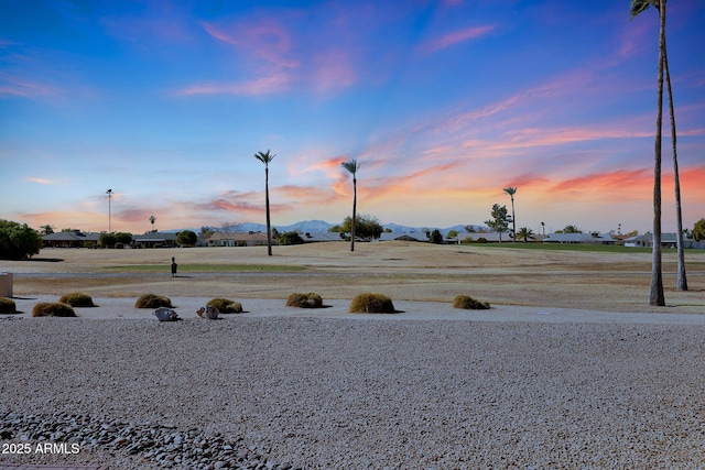 yard at dusk featuring a mountain view