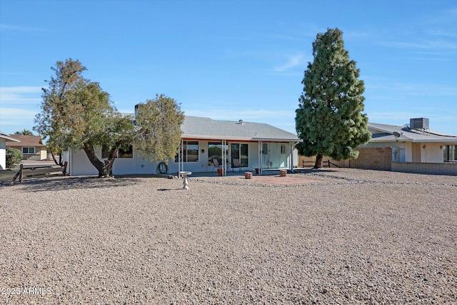 ranch-style house with central AC unit and a patio