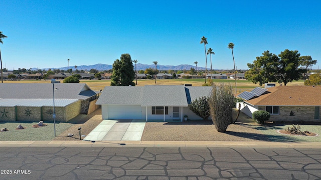 view of front of house featuring a mountain view, a garage, and solar panels