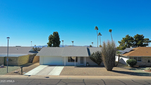 ranch-style house with a garage and solar panels