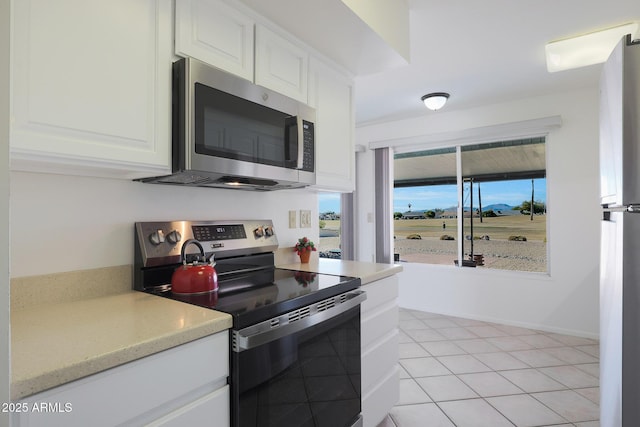 kitchen with white cabinetry, appliances with stainless steel finishes, and light tile patterned floors