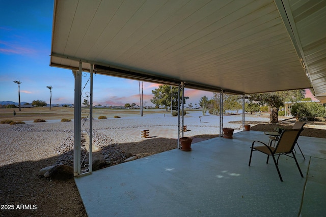 patio terrace at dusk featuring a water view